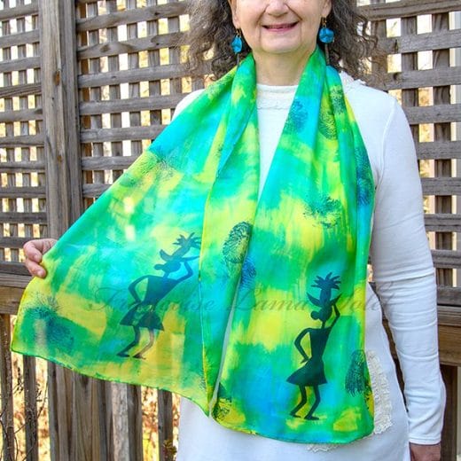 Women's silk scarf hand painted with an abstract blue, green and yellow pattern and hand printed with tribal patterns.