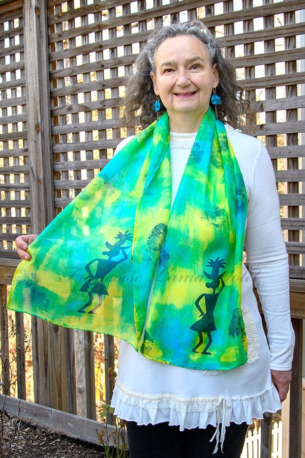 Women's silk scarf hand painted with an abstract blue, green and yellow pattern and hand printed with tribal patterns.