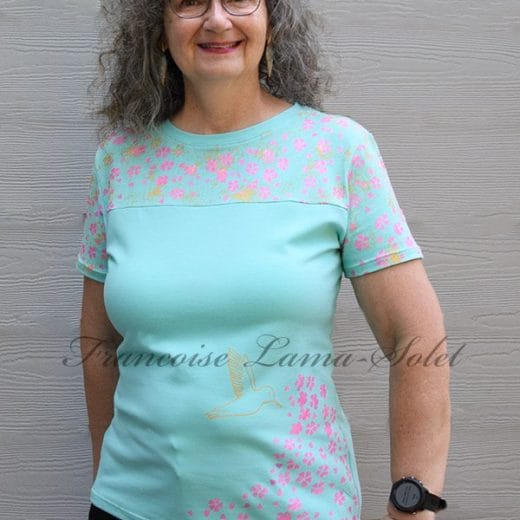 Stay stylish with this handmade mint cotton t-shirt featuring pink cherry blossoms and gold hummingbirds. Each shirt is a unique piece of art!