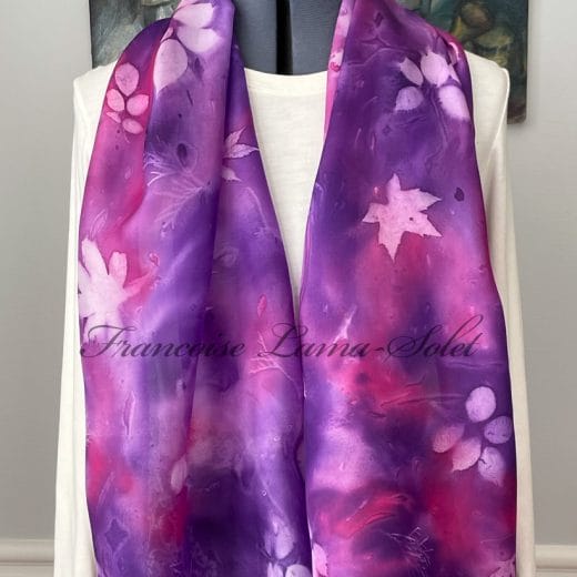 Women hand painted pink and purple silk scarf with leaf patterns.