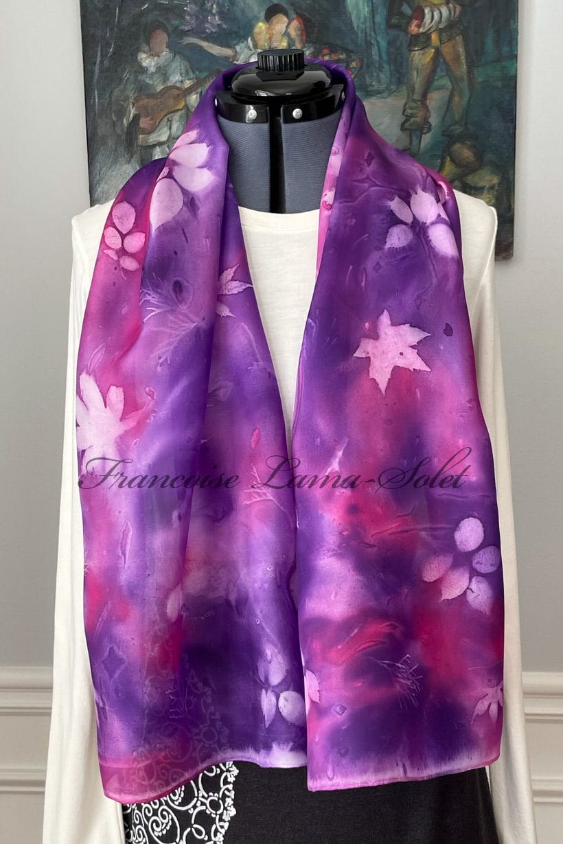 Women hand painted pink and purple silk scarf with leaf patterns.