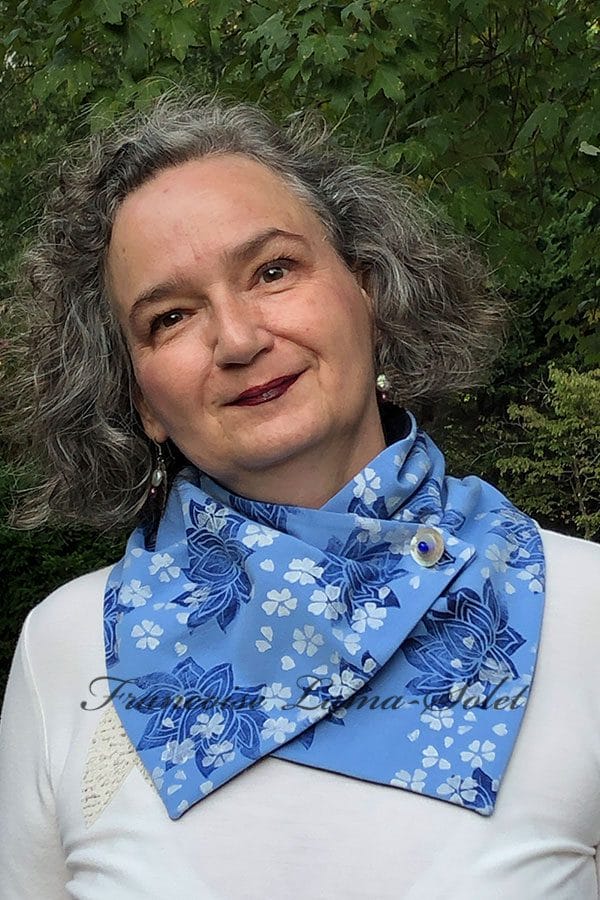 Women's blue button neck scarf handmade and hand printed with cherry blossoms and lotus flowers.