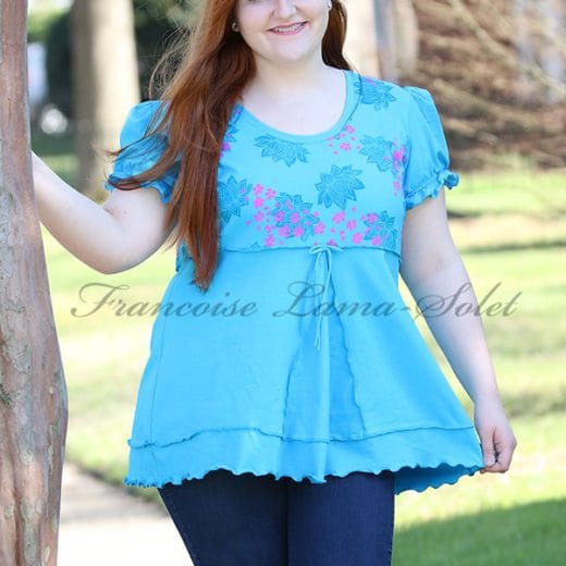 Women's empire waist tunic with puff sleeves handmade with a turquoise cotton lycra jersey and hand printed with lotus flowers and cherry blossoms.