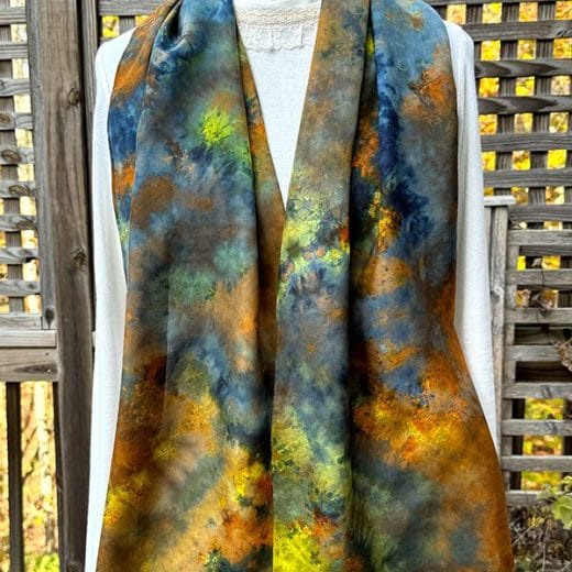 Women's ice dyed silk scarf in different shades of blue, brown, copper, yellow and green.
