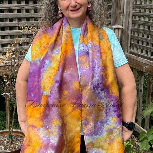 Women's hand ice dyed silk scarf in different shades of orange and purple.