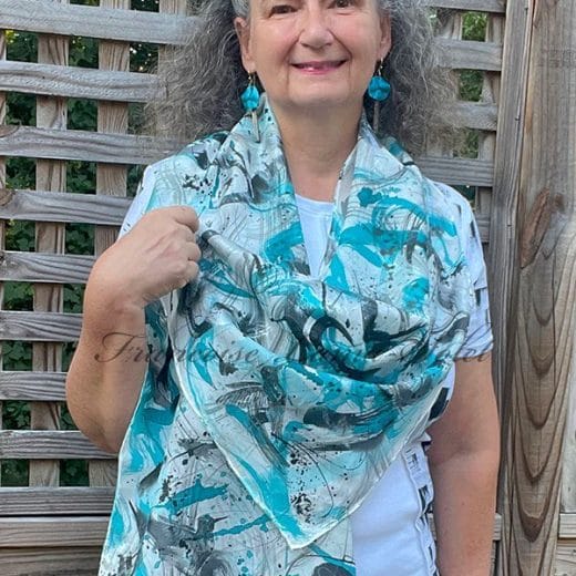 Women's silk scarf hand painted with a blue and black artwork and hand printed with black hummingbirds.