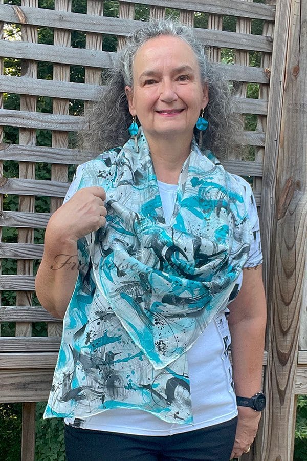 Women's silk scarf hand painted with a blue and black artwork and hand printed with black hummingbirds.