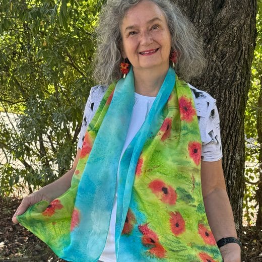 Vibrant hand painted silk scarf featuring red poppies in a field