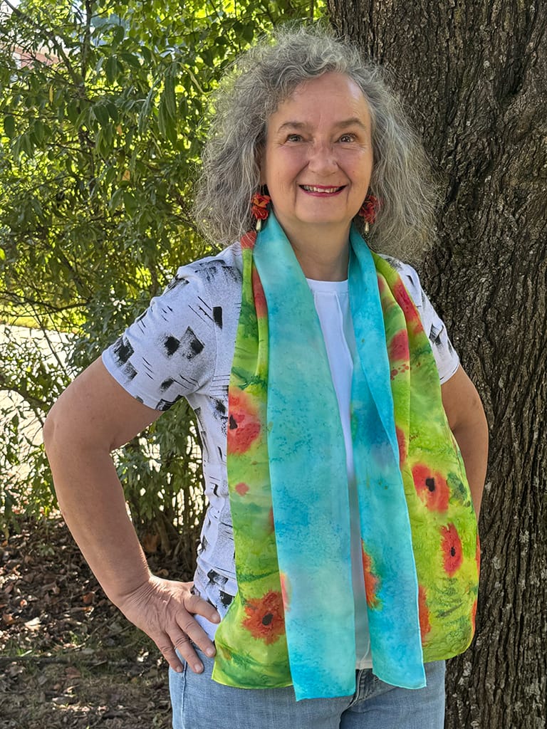 Vibrant hand painted silk scarf featuring red poppies in a field