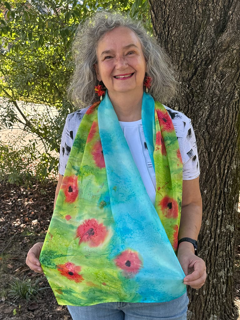 Vibrant hand painted silk scarf featuring red poppies in a field