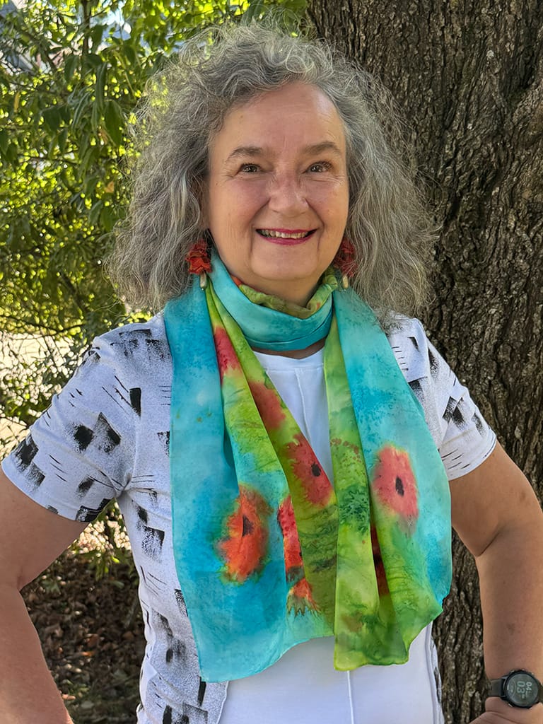 Vibrant hand painted silk scarf featuring red poppies in a field