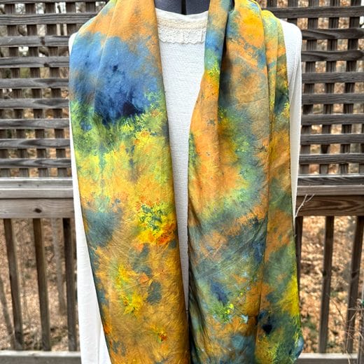 Women's ice dyed silk scarf in different shades of blue, brown, copper, yellow and green.